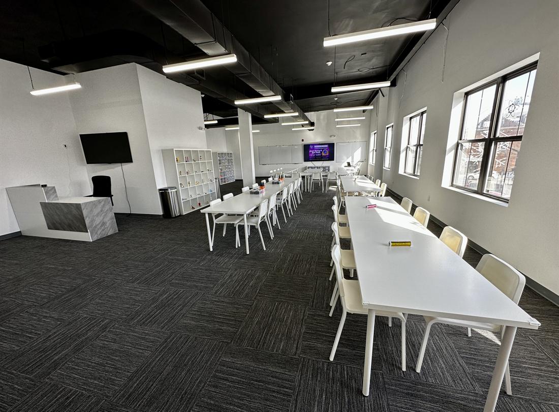 Inside the Exploratores classroom on East Broad Street: bright room, long white worktables and a project shelf